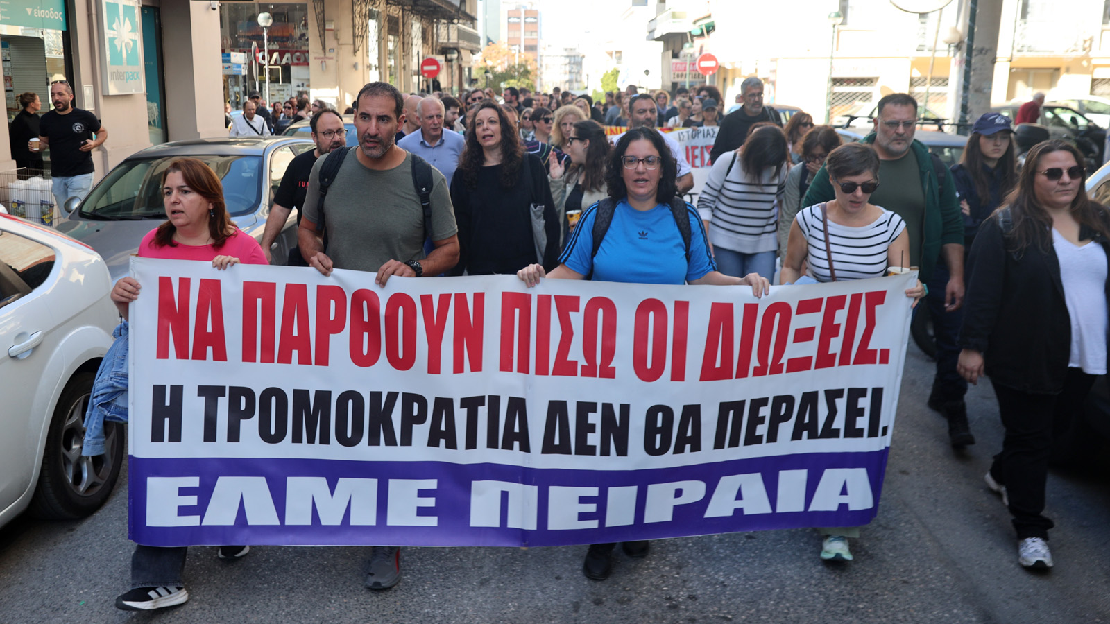 Εκπαιδευτικοί της ΕΛΜΕ Πειραιά κρατούν πανό ενάντια στις διώξεις