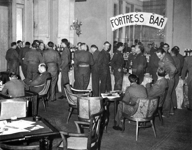 Βρετανοί αξιωματικοί ξέγνοιαστοι στο μπαρ της «Μεγάλης Βρετανίας. Εκεί δεν φτάνει ο αχός της μάχης. (Φωτογραφία του Dmitri Kessel «Ελλάδα του ’44», εκδόσεις ΑΜΜΟΣ, Αθήνα 1994).