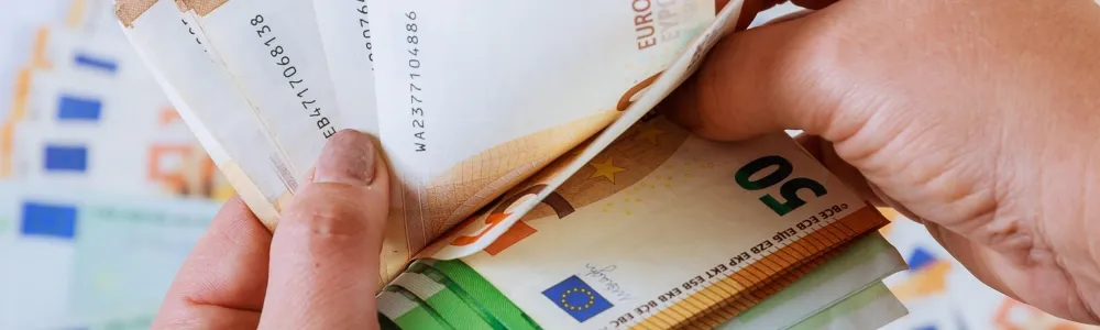 Ανδρικά χέρια μετράνε το εφάπαξ σε χρήματα