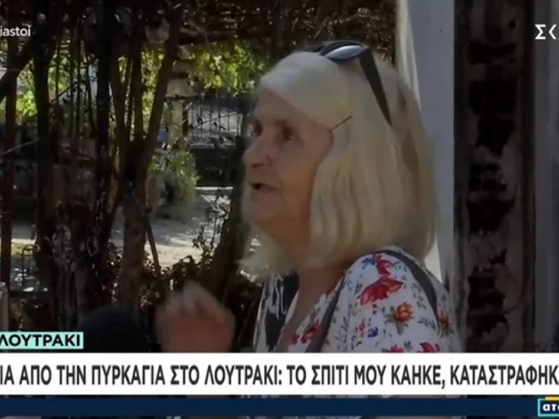 Γυναίκα μπροστά στο καμένο σπίτι της στο Λουτράκι