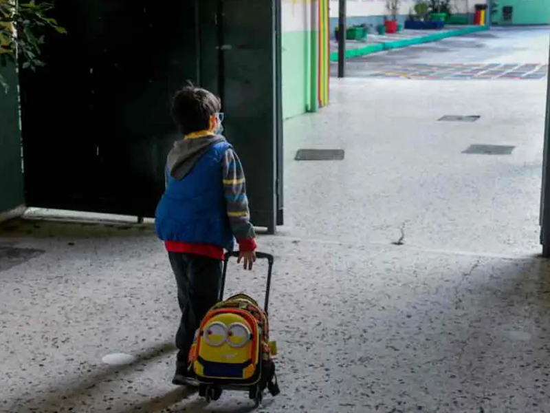 Παιδί με τσάντα μπαίνει σε τάξη σχολείου