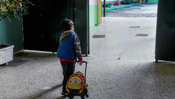 Παιδί με τσάντα μπαίνει σε τάξη σχολείου