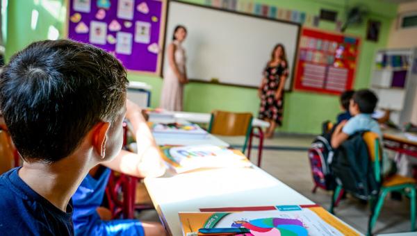 σχολείο, τάξη, δασκάλα κάνει μάθημε σε μαθητές που κάθονται στα θρανία