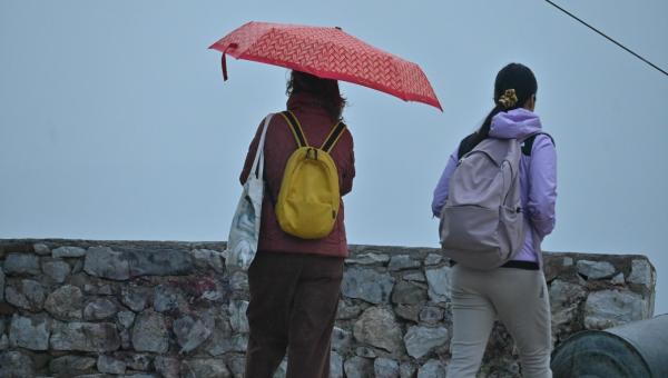 κακοκαιρία, καιρός και γυναίκες κρατούν ομπρέλες στη βροχή