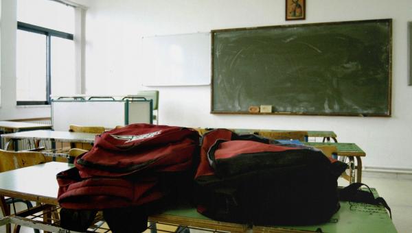 Άδεια σχολική τάξη με τσάντες πάνω σε θρανίο