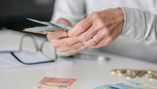 Γυναίκα συνταξιούχους μετράει χρήματα συνταξιοδότησης – αλλαγές στη φορολογία για πρόωρη σύνταξη και ΤΕΑ
