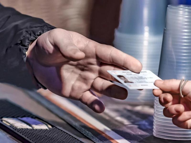 Άντρας δίνει σε γυναίκα ταυτότητα, φαίνονται μόνο τα χέρια τους