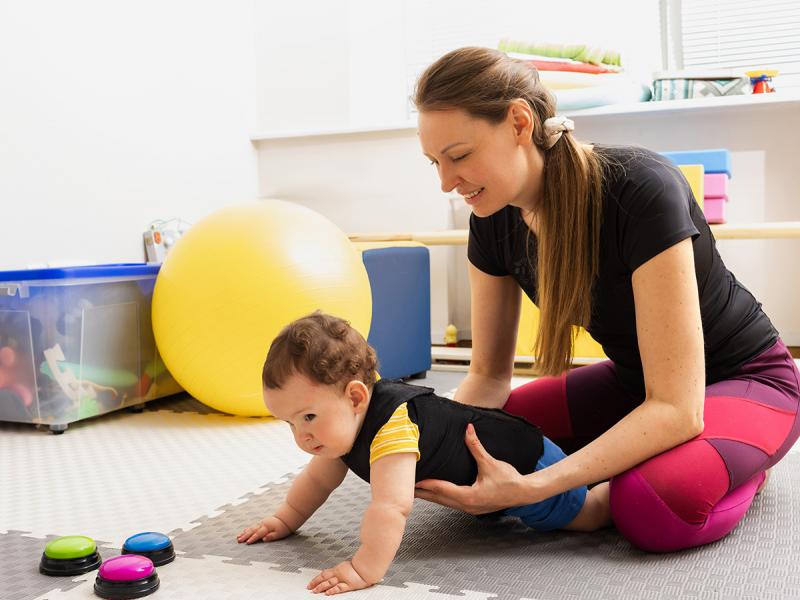 Γυναίκα κρατάει μωρό παιδί που μπουσουλάει