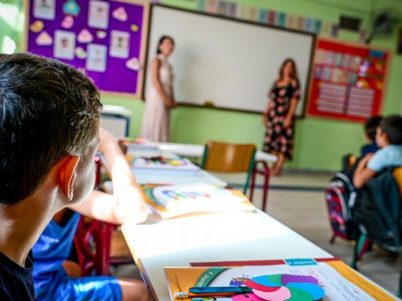 σχολείο, τάξη, δασκάλα κάνει μάθημε σε μαθητές που κάθονται στα θρανία