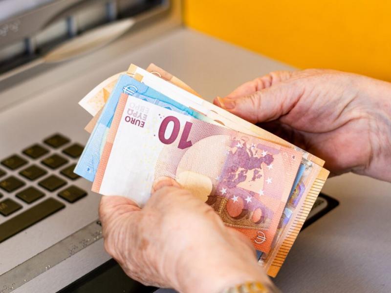 Γυναίκα συνταξιούχους μετράει ευρώ σε χαρτονομίσματα