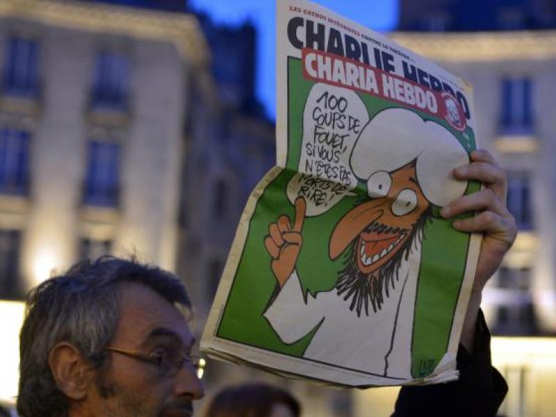 461131044-man-holds-up-a-charlie-hebdo-magazine-during-a-rally-at.jpg.crop_.promo-mediumlarge.jpg