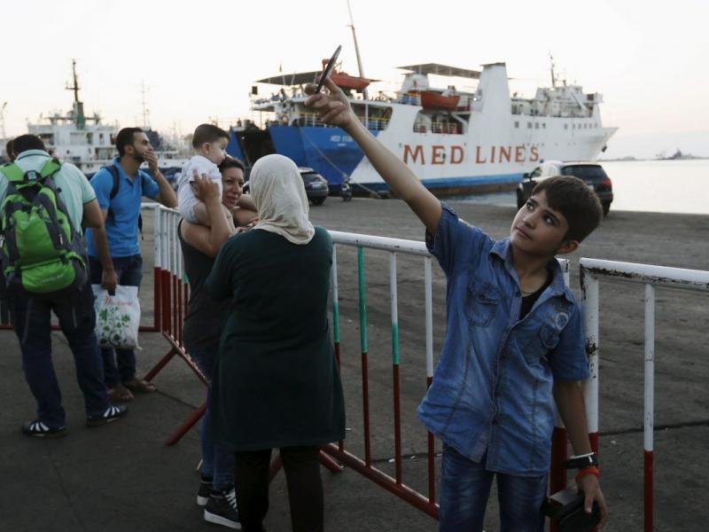 a-syrian-boy-takes-a-selfie-as-he-waits-with-his-family-at-lebanons-northern-tripoli-port-for-a-passenger-ferry-to-turkey.jpg