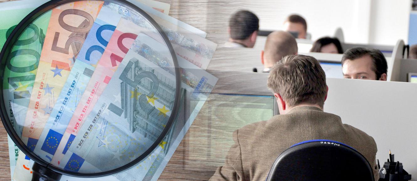Χρήματα σε ευρώ, μεγεθυντικός φακός και υπάλληλοι σε υπολογιστές
