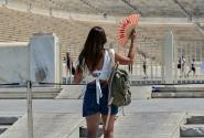 Κοπέλα κάνει αέρα με βεντάλια έξω από το παναθηναικό στάδιο λόγω καύσωνα