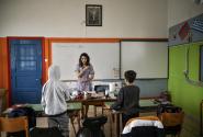 Εκπαιδευτικός σε αίθουσα σχολείου μιλάει με παιδιά