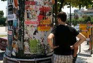 φοιτητής ψάχνει για σπίτι κοιτώντας αγγελίες στο δρόμο