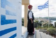 Μαθητής σε σχολείο με παραδοσιακή στολή και την Ελληνική σημαία