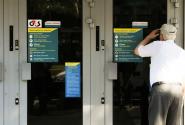Συνταξιούχος σε τράπεζα κοιτάει μέσα από το τζάμι