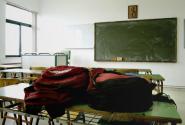 Άδεια σχολική τάξη με τσάντες πάνω σε θρανίο 