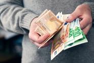 Άνδρας μετράει χρήματα και ευρώ με τα χέρια του