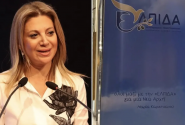 Η Μαρία Καρυστιανού με φόντο το λογότυπο του κόμματός της «Ελπίδα»