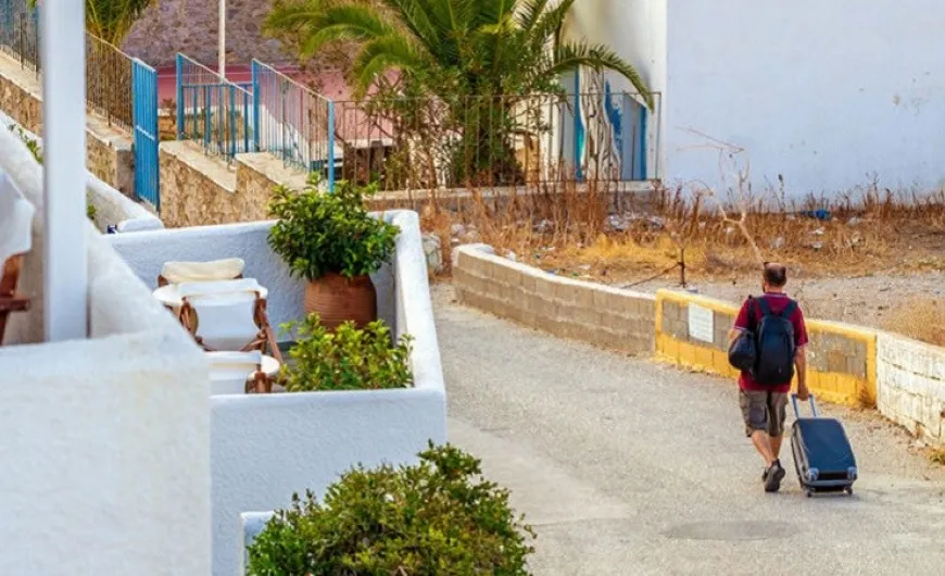Άνδρας περπατάει με βαλίτσα στο χέρι σε νησί