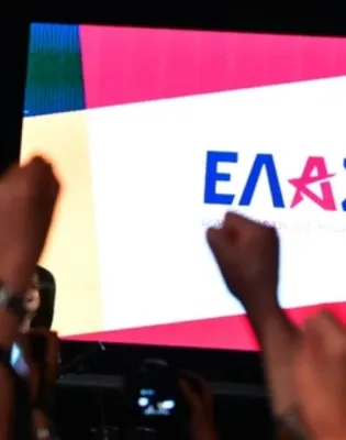 Ο Αλέξης Τσίπρας και στο βάθος λογότυπο από την Ελληνική Αριστερή Συμπαράταξη (ΕΛΑΣ)