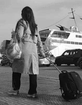 Γυναίκα εκπαιδευτικός αναπληρώτρια με βαλίτσα στο χέρι ετοιμάζει να μπει σε καράβι