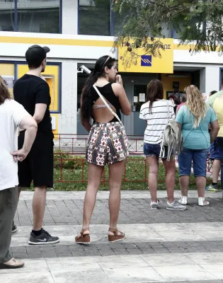Κόσμος περιμένει για ανάληψη χρημάτων από ΑΤΜ τράπεζας