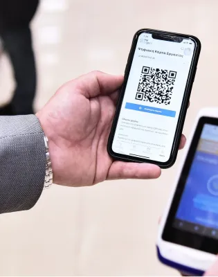 Ανδρικά χέρια κρατάνε κινητό με barcode μέσα από την εφαρμογή του ΕΡΓΑΝΗ