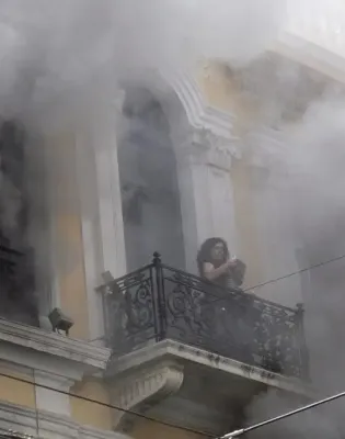 Γυναίκα στο μπαλκόνι της τράπεζας Marfin μέσα σε καπνούς από τον εμπρησμό το 2010