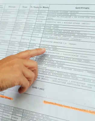 Υποψήφιος στις Πανελλαδικές εξετάσεις κοιτάζει τις βάσεις σε πίνακα