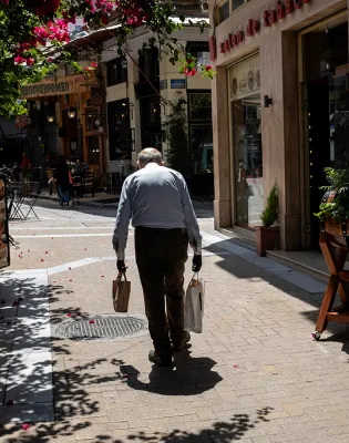 Συνταξιούχος περπατάει σε σοκάκι της Αθήνας