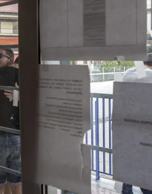 Αγκαλιασμένοι επιτυχόντες στις Πανελλαδικές κοιτάζουν τις Βάσεις εισαγωγής 2026