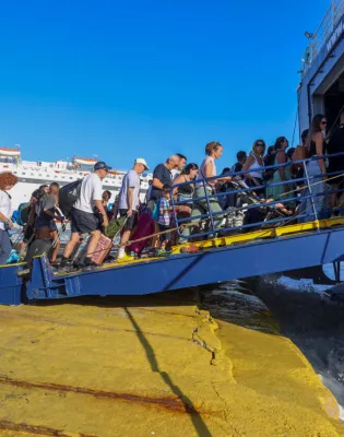 Άνθρωποι, τουρίστες και εκπαιδευτικοί επιβιβάζονται με βαλίτσες σε πλοίο για ταξίδι