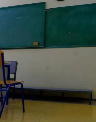 Άδεια αίθουσα τάξης μετά την απόλυση δασκάλας, φαίνεται καρέκλα, έδρα και πίνακας