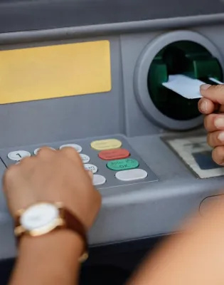 Γυναίκα βάζει την κάρτα της σε μηχάνημα ΑΤΜ για να πληρωθεί από ΔΥΠΑ και e-ΕΦΚΑ