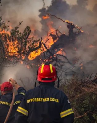 Πυροσβέστες την ώρα που προσπαθούν να σβήσουν φωτιά με μάνικα