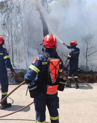 Εποχικοί πυροσβέστες ενώ σβήνουν φωτιά