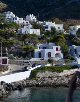 Γυναίκα αγναντεύει σε παραθαλάσσιο οικισμό σε νησί κάνοντας διακοπές