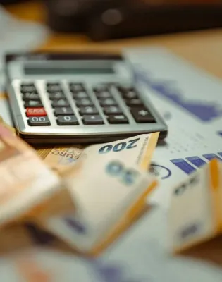 Χρήματα σε χαρτονομίσματα ευρώ δίπλα από κομπιουτεράκι