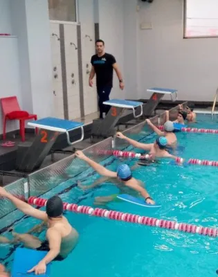 Γυμναστής σε κολυμβητήριο κάνει μάθημα σε παιδιά που είναι μέσα στην πισίνα