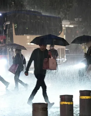 Άνθρωποι με ομπρέλες τρέχουν να προστατευτούν από καταιγίδα στην Αττική