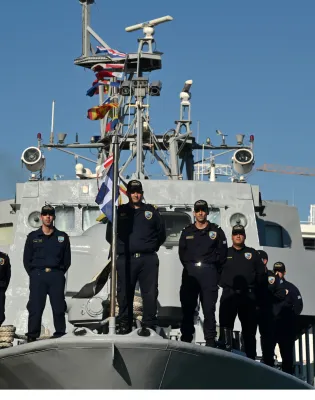 Άνδες και γυναίκες του Λιμενικού Σώματος ποζάρουν επάνω σε σκάφος του Λιμενικού