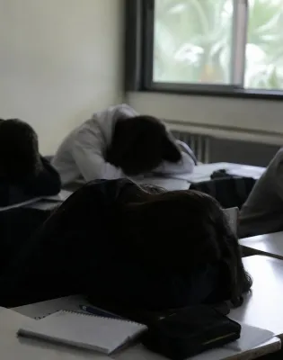Μαθητές με σκυμμένα κεφάλια πάνω σε θρανία στις Πανελλαδικές εξετάσεις