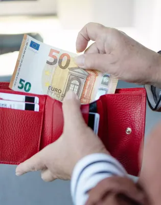 Γυναίκα μετράει χρήματα στο πορτοφόλι της