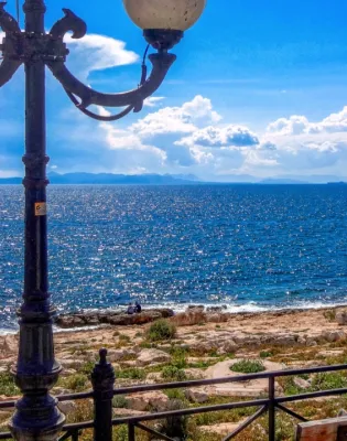 Γυναίκες κάθονται σε παγκάκι σε παραλία με καλό καιρό τον χειμώνα