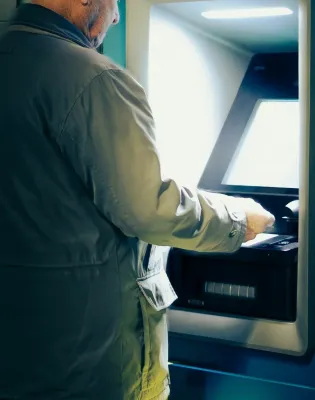 Άνδρας σηκώνει τη σύνταξή του με χρήματα από ATM τράπεζας