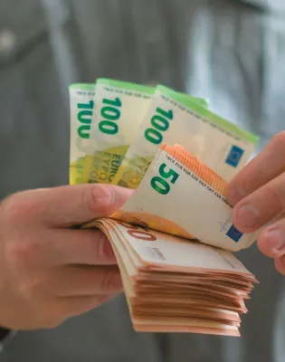 Άνδρας μετράει χαρτονομίσματα με ευρώ