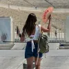 Κοπέλα κάνει αέρα με βεντάλια έξω από το παναθηναικό στάδιο λόγω καύσωνα